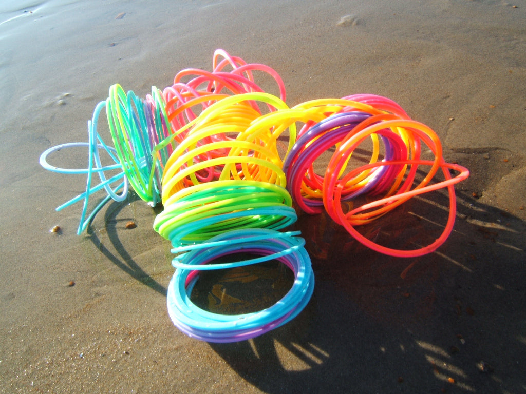An extremely tangled rainbow slinky on a beach