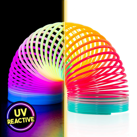 A split-screen product image of The Original HyperSpring™ (3.4") in Rainbow Opaque. The left side shows the spring glowing in vibrant neon pink, blue, and yellow under a UV blacklight. The right side shows the spring under normal light, displaying solid, opaque rainbow gradients. A "UV Reactive" badge is visible in the bottom corner.