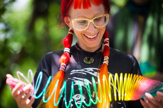 Woman with red hair smiling while playing with a Translucent Glitter Original HyperSpring
